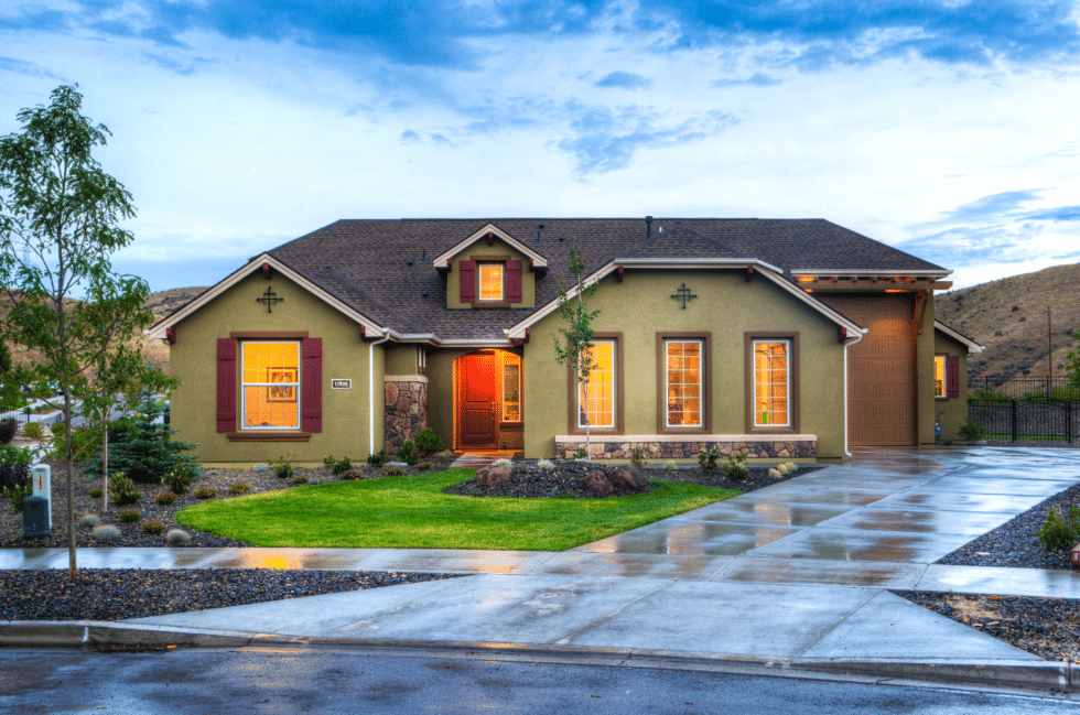 green painted home with driveway