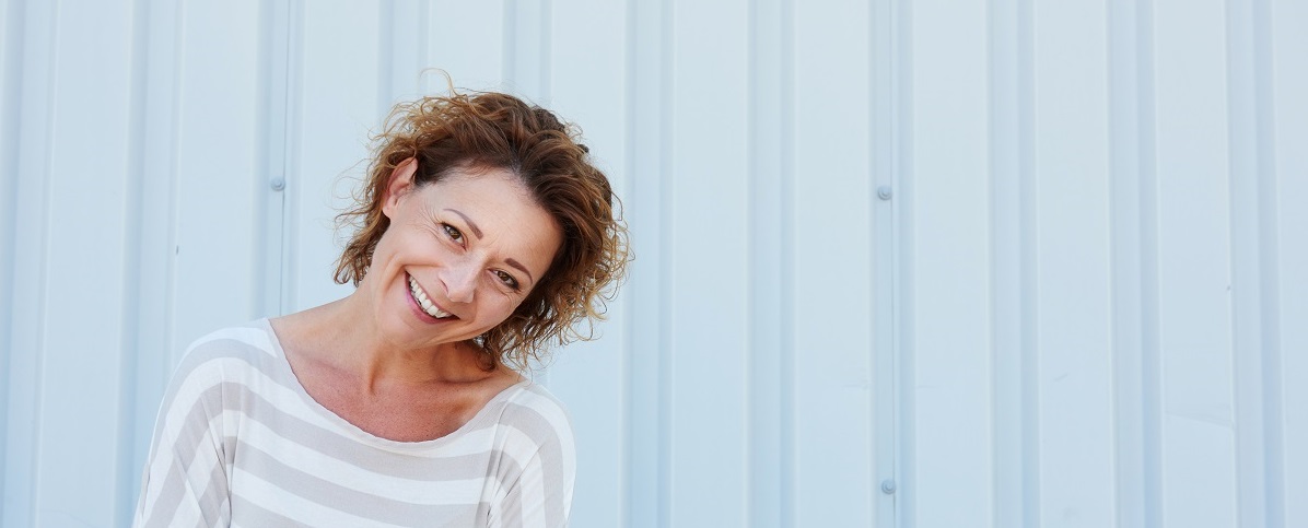 Casual older woman standing and laughing