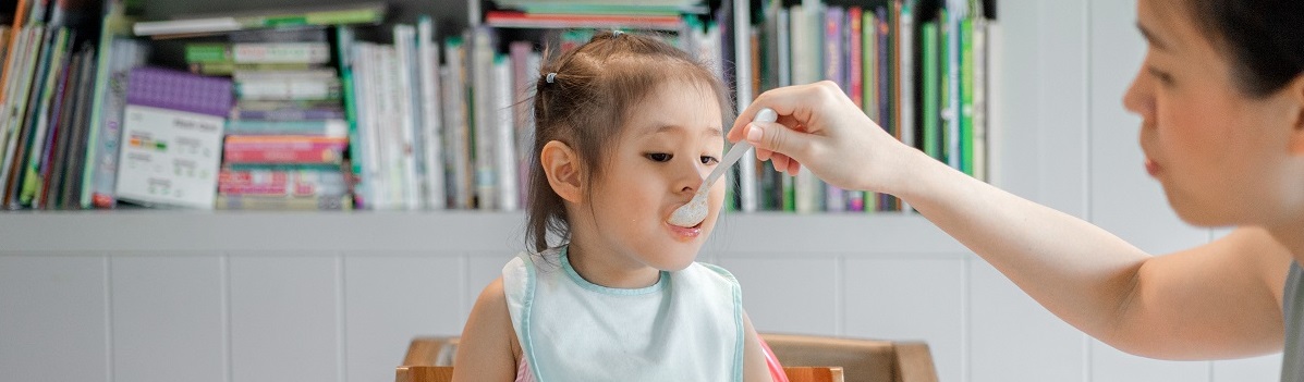 a younh child being fed at the table