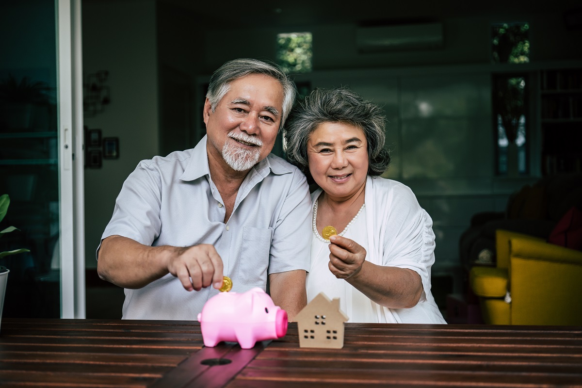 Elderly Couples talking about finance with piggy bank