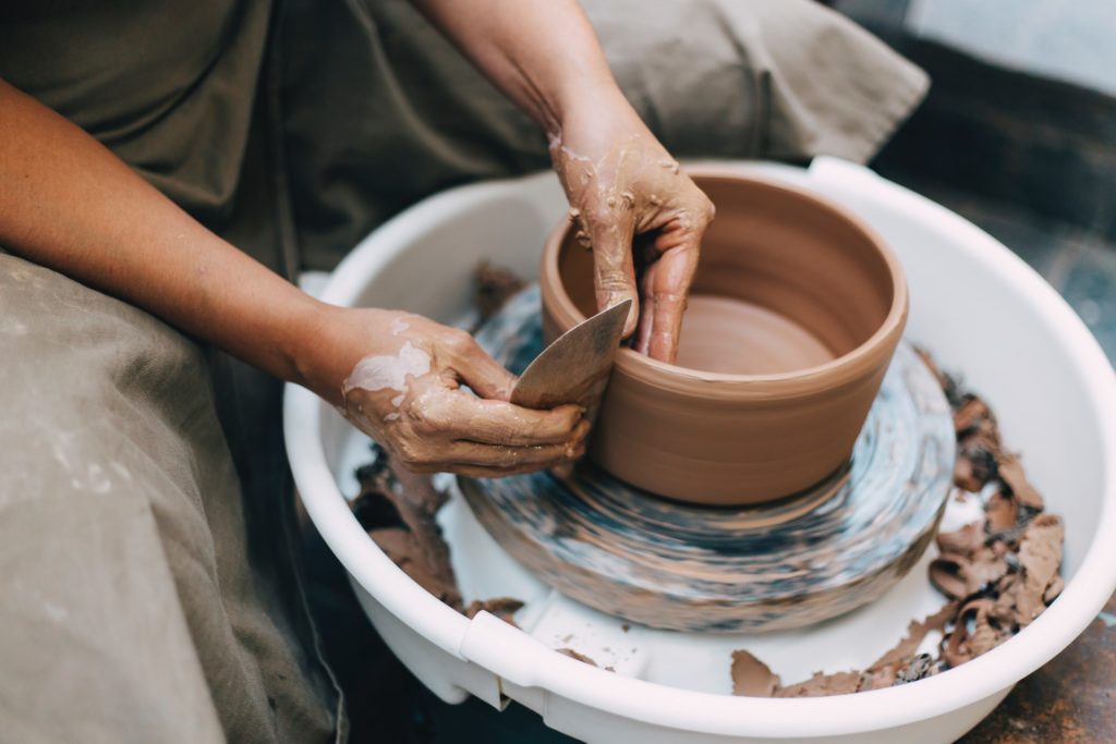 a person throwing clay on a pottery wheel