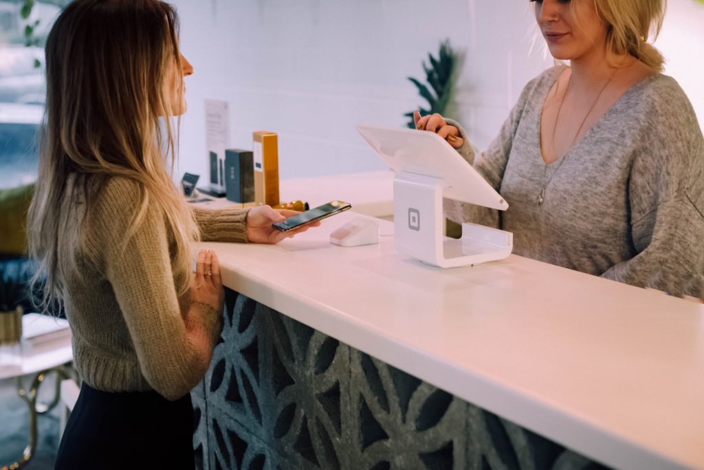 a woman and customer paying with a credit card