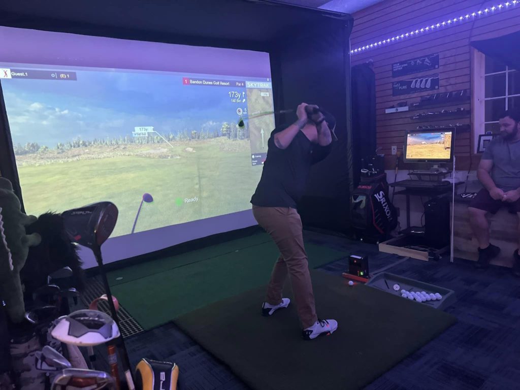 man swinging club using golf simulator at Willow Lake Golf Center & Driving Range, Keizer, Oregon