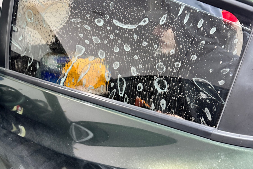 1. Car window covered in soapy solution during tint installation.