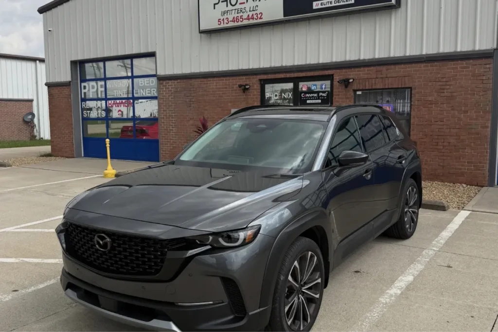 Dark grey Mazda SUV featuring dark window tint on side and rear windows.